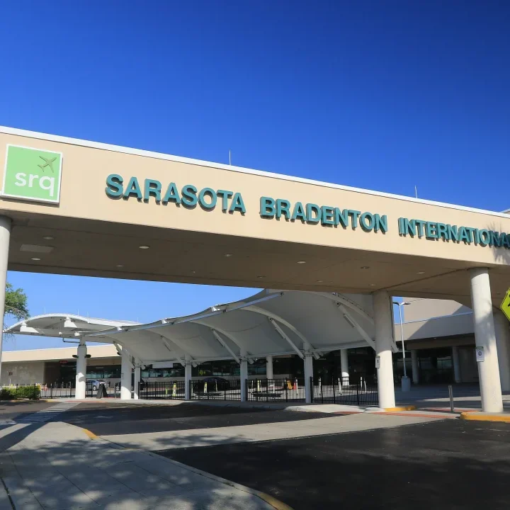 A large white building with a green sign on it.